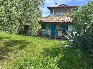 ein kleines Haus mit blauen Türen in einem Hof in der Unterkunft Norbin in Gračišče