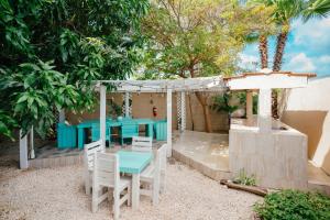a patio with a blue table and white chairs at Hotel RH Boutique Aruba in Oranjestad