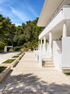 a row of white benches on the side of a building at Petra Maris B&B in Peschici