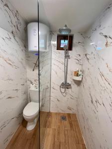 a bathroom with a toilet and a glass shower stall at Underwoods_chill in Žabljak +16 photos