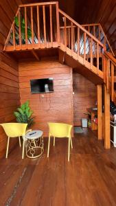 a living room with two chairs and a staircase at Cabin Dieng Db in Diyeng