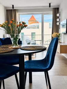 a dining room with a table and blue chairs at Penthouse21 in Oświęcim