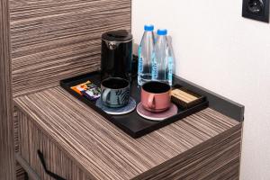 a shelf in a cabinet with two bottles and cups at Gulshan Hotel in Urganch