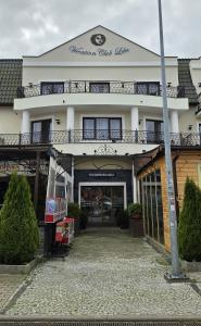 a white building with a balcony on top of it at Vacation Club Łeba in Łeba