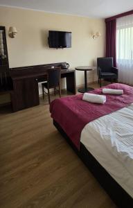 a hotel room with a bed and a desk at Vacation Club Łeba in Łeba +9 photos
