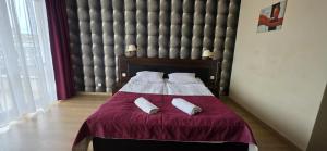a bedroom with a bed with two pillows on it at Vacation Club Łeba in Łeba