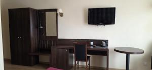 a desk with a chair and a television on a wall at Vacation Club Łeba in Łeba