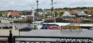 a boat docked at a marina with cars parked at Vacation Club Łeba in Łeba