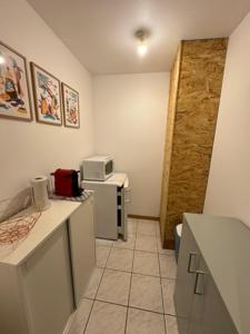 a kitchen with white counters and a microwave at Au Chevaleins in Chaleins