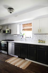 a kitchen with black and white cabinets and a sink at Sea Fog Cottage in Camden