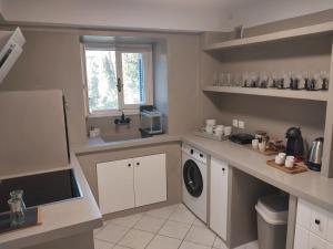 a kitchen with a sink and a washing machine at Margarita's Home in Steniaí