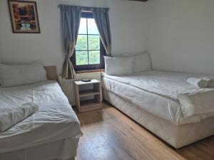 two beds in a room with a window at Къща Цачеви in Tryavna +8 photos