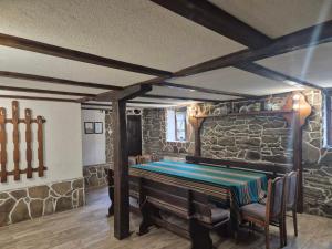 a room with a piano in a stone wall at Къща Цачеви in Tryavna
