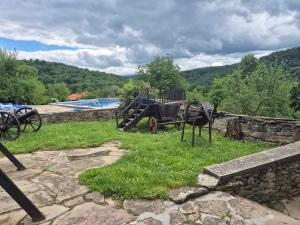 an old carriage sitting on top of a stone wall at Къща Цачеви in Tryavna