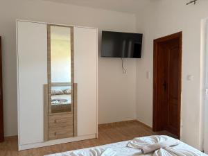 a bedroom with a mirror and a tv on a wall at Eki 2026 VIP in Donji Štoj