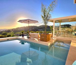 a house with a swimming pool with an umbrella at Le Nid Bleu in Le Beausset