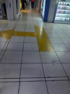 a tiled hallway with a yellow x on the floor at Hospedaje Maljut in Lima