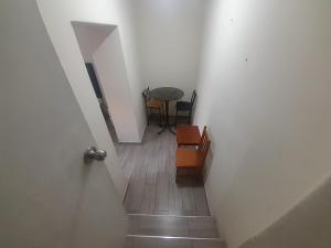 a hallway with a stairway with a table and chairs at Hospedaje Maljut in Lima