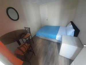 a small bedroom with a bed and a table at Hospedaje Maljut in Lima