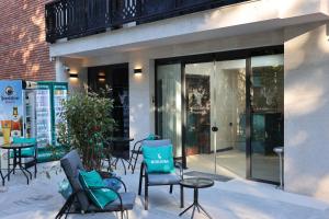 a group of chairs and tables in front of a building at Borjomind Hotel Borjomi in Borjomi