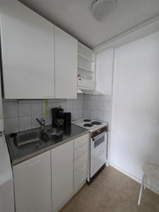 a small kitchen with a sink and a stove at Central Accommodation at Olavinkatu in Savonlinna
