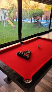 a red pool table with a billiard sidxternessternessternessternessstrationstrationterness at Hospedaje en Monte Grande in Monte Grande