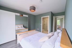 a bedroom with a large white bed in a room at 3 Bedroom Duplex Apartment By Travel Lets Short Term Rental Agency Donegal Town in Donegal