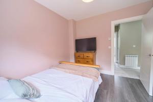 a bedroom with a bed and a flat screen tv at 3 Bedroom Duplex Apartment By Travel Lets Short Term Rental Agency Donegal Town in Donegal