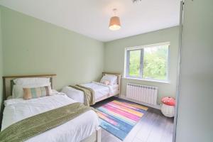 a small bedroom with two beds and a window at 3 Bedroom Duplex Apartment By Travel Lets Short Term Rental Agency Donegal Town in Donegal