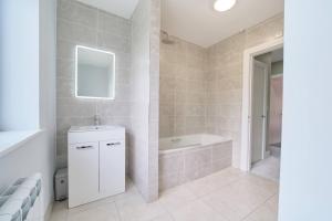 a bathroom with a tub and a sink and a mirror at 3 Bedroom Duplex Apartment By Travel Lets Short Term Rental Agency Donegal Town in Donegal +40 photos