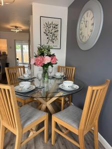 a dining room table with chairs and a clock on the wall at Stanley Cottage in Herne Bay +6 photos