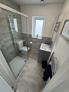 a bathroom with a shower and a toilet and a sink at Stanley Cottage in Herne Bay