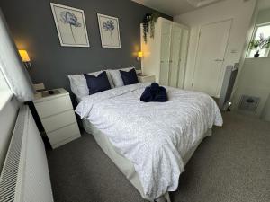 a bedroom with a bed with a white comforter at Stanley Cottage in Herne Bay