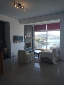ein Wohnzimmer mit Sofa und großem Fenster in der Unterkunft Mousonette in Selínia