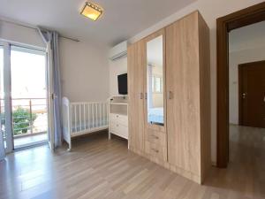 a room with a large wooden closet with a television at Apartment Orange Blossom First Line & Pool 2 in Bijela