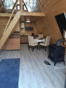 a kitchen and dining room with a stove in a cabin at Aframe Iza in Bradu