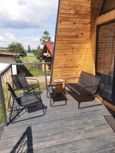 a deck with four chairs and a wooden building at Aframe Iza in Bradu