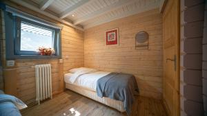 a small bedroom with a bed and a window at Vakantiewoning Vrijburg in Schagerbrug