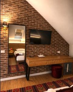 a hotel room with a brick wall and a mirror at Hotel Protino in Fushë-Prezë