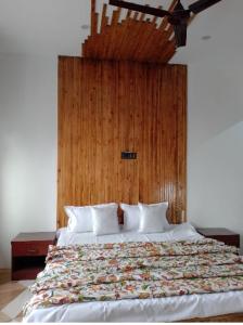 a bedroom with a large bed with a wooden headboard at Rooebarpur in Khāniyār