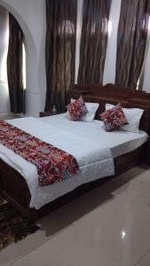 a bedroom with a large bed with red pillows at Rooebarpur in Khāniyār