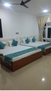 a bedroom with two beds with blue pillows at Rooebarpur in Khāniyār