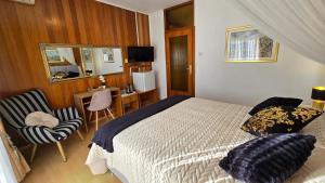 a bedroom with a bed and a chair and a desk at Avalena Residence in Zadar