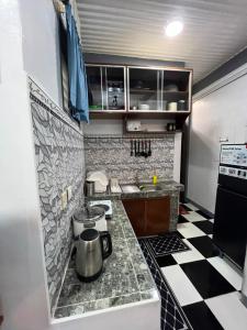 a small kitchen with a black and white checkered floor at Tiya Cheding Boarding House in Carolina