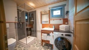a bathroom with a shower and a washing machine at Vakantiewoning Vrijburg in Schagerbrug +48 photos