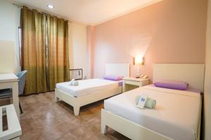 a hotel room with two beds and a window at The Inns Bacolod in Bacolod