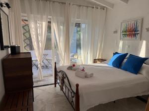a bedroom with a bed with blue pillows and a window at Villa eco Electra in Nikiti +48 photos
