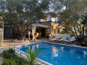 a swimming pool with lounge chairs and a house at Villa eco Electra in Nikiti
