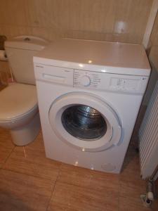 a washing machine in a bathroom with a toilet at Διαμέρισμα τεσσάρων ατόμων in Filiatra
