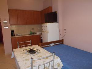 a small kitchen with a table and a white refrigerator at Διαμέρισμα τεσσάρων ατόμων in Filiatra